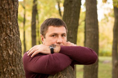 Orta yaşlı bir adam sonbahar ormanında dinleniyor. Portre.