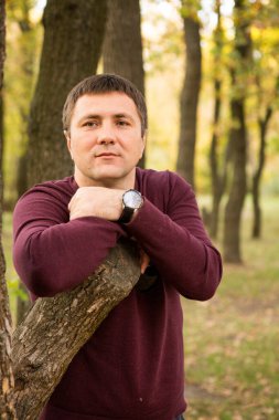 Orta yaşlı bir adam sonbahar ormanında dinleniyor. Portre.