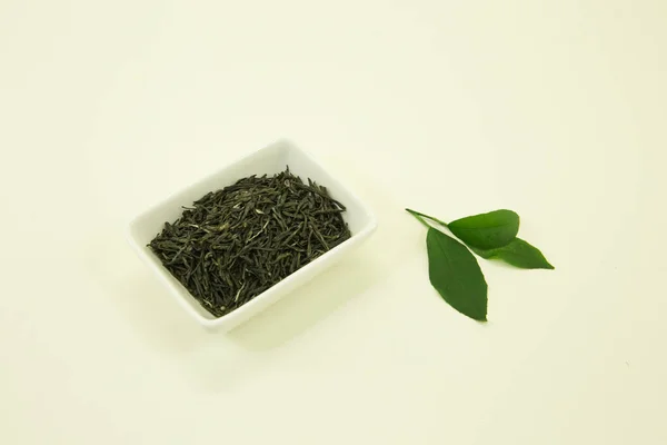 中国の緑茶 湖北省 の緑茶 レモンの葉 白い背景の白い鉢に隔離されている — ストック写真