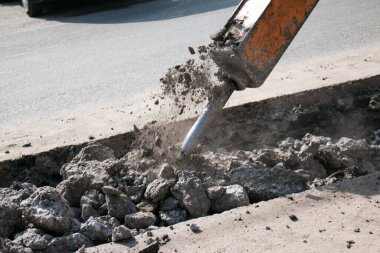 Çok katlı yeni bir binanın inşaatı. Temeli atarken bir kaya matkabının çalışması.