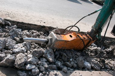 Çok katlı yeni bir binanın inşaatı. Temeli atarken bir kaya matkabının çalışması.