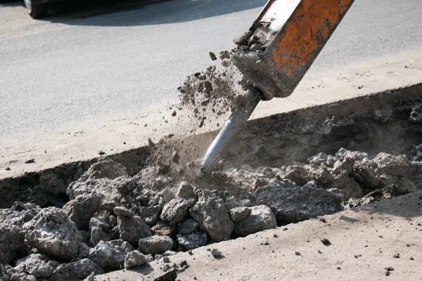 Çok katlı yeni bir binanın inşaatı. Temeli atarken bir kaya matkabının çalışması.