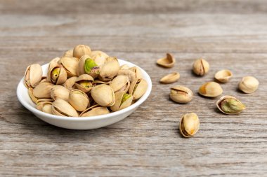 Ahşap arka plan üzerinde beyaz plaka tuzlu fıstık