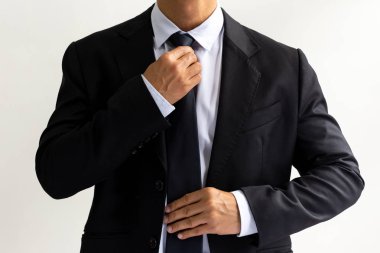 İşadamı kravat bağlama beyaz arka planda siyah elbiseli