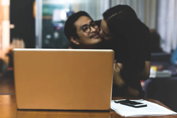 Vrouw Geeft Haar Man Een Kus Terwijl Hij Computer Thuis — Stockfoto