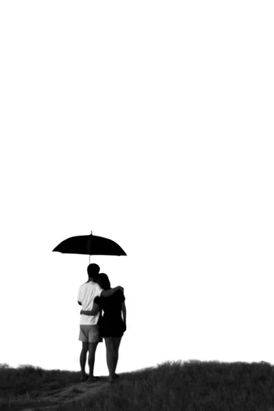 Blurred concept silhouette couple standing on the hill and holding umbrella in black and white. — Stock Photo, Image