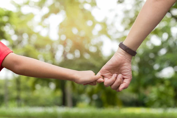 Madre e hijo enganchando el dedo hacen su promesa mientras caminan en el parque en verano . — Foto de Stock