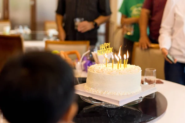 Familie mit Kerzenkuchen feiert Geburtstagsparty im Restaurant. — Stockfoto