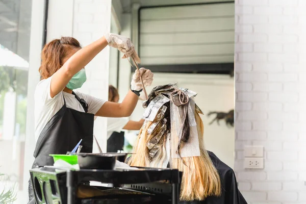 Peluquería está muriendo pelo femenino con papel de aluminio en el salón . — Foto de Stock