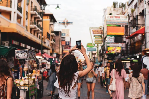 Turystyczna Kobiety Robienie zdjęć z jej telefon komórkowy na ulicy w niewyraźne tło. — Zdjęcie stockowe