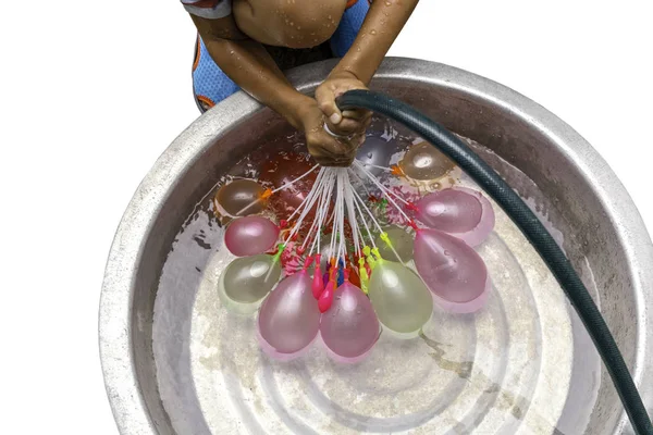 Мальчик с водяным шлангом, наполняющим красочные воздушные шары, изолированные на пути обрезки . — стоковое фото