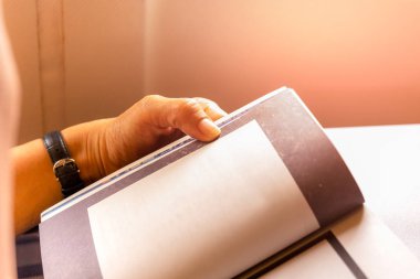 Kadın yolcu uçakta seyahat ederken kitap okuyarak zaman öldürmek.