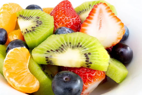 Feche a salada de fruto fresca macro em uma chapa branca . — Fotografia de Stock