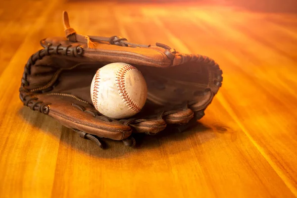 Baseball catcher mitt with ball on wooden table. — Stock Photo, Image