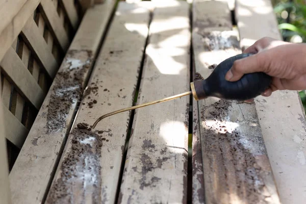 Obrero pulverización de insecticida químico para el control de plagas de termitas en cubierta de madera . — Foto de Stock