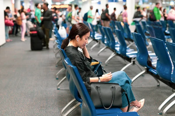 Woman using cell phone waiting for borading at the airport terminal. — Stock Photo, Image
