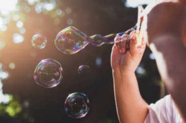 Kabarcık halka aracılığıyla kabarcık güneş ışığında üfleme bulanık kavramı kişi.