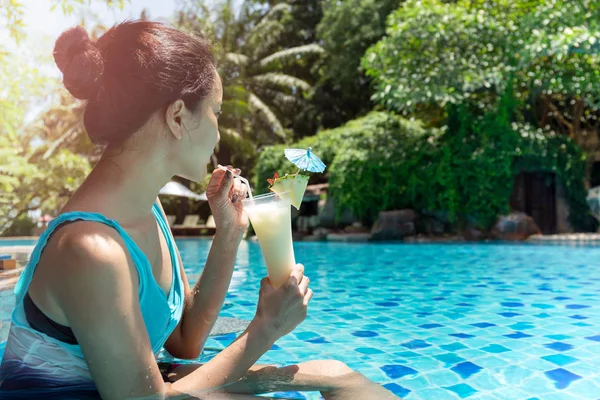 Belle femme asiatique ayant cocktail dans la piscine en vacances . — Photo