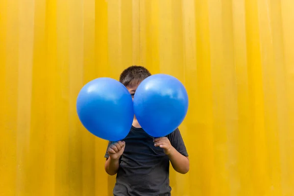 Boy Holding Blue Balloons Standing Yellow Background — Stock Photo, Image