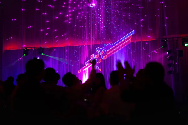 Blurred concept at concert party with audience and colourful led lighting