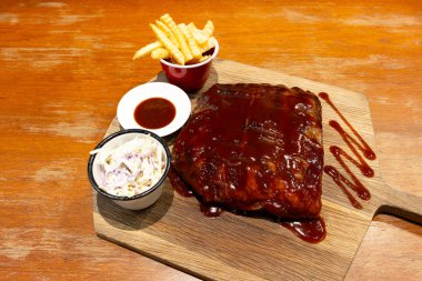 Barbekü domuz eti yedek kaburga sos ve ahşap tahta üzerinde çip ile