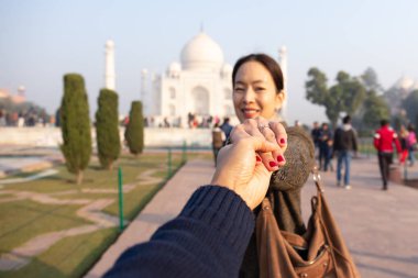 Karım elini gösteren evlilik yüzüğünü Taj Mahal ile arka planda tutan adam