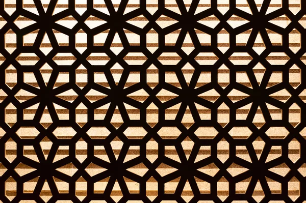 Wooden carve pattern decoration on the wall with lighting in background