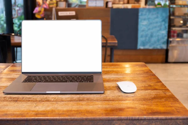 Blank screen laptop with mouse on table in cafe