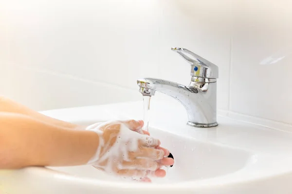 お風呂の蛇口の流水で石鹸で手を洗う水道水子供の選択と集中 — ストック写真