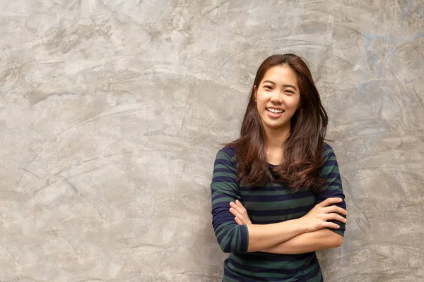 Fiatal szép ázsiai nő mosolyogva a beton szürke háttér. — Stock Fotó