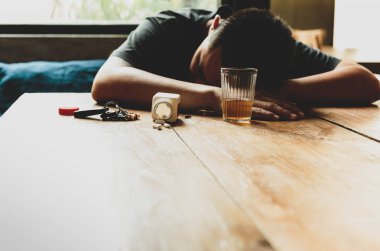 Sarhoş adam masada uyku hapları ve bardak viski ve 