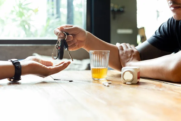 Drinking no driving concept. Drunk man giving car key to his to