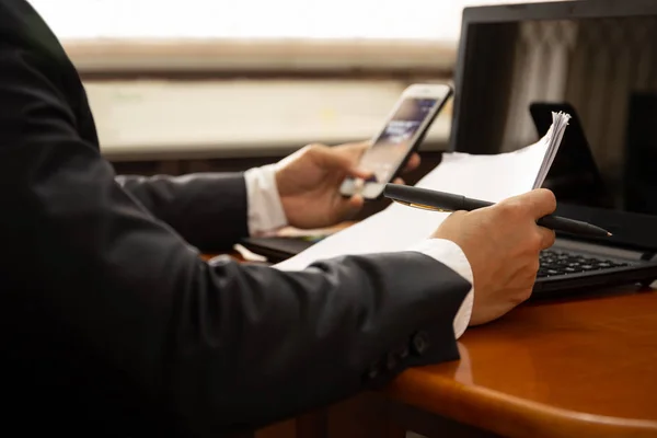 Zakenman werken op papier van de documenten met behulp van de mobiele telefoon en laptop. — Stockfoto