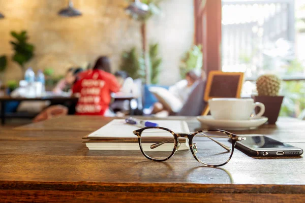 Seçilen odak gözlük ve ahşap masa cep telefonu.