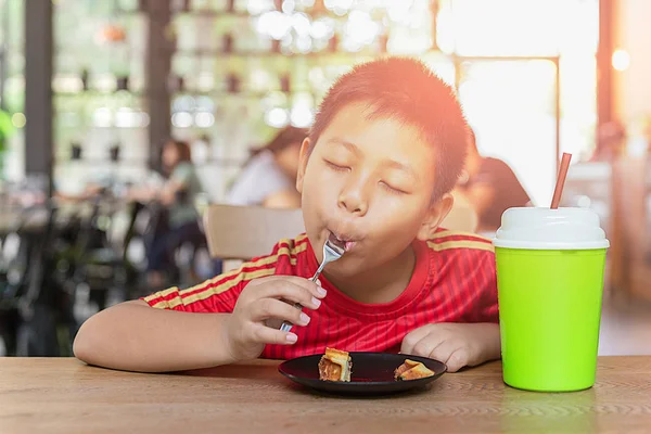 Feliz cara asiático chico disfrutar comer chocolate waffle en restaurante . —  Fotos de Stock