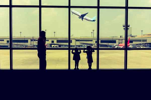 Family watching the plane takes off while waiting for boarding i — Stock Photo, Image