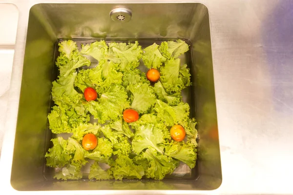 Lavagem de legumes frescos na pia da cozinha conceito de cuidados saudáveis . — Fotografia de Stock