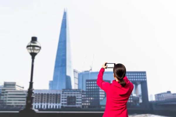 Turist kadın cep telefonu ile bina ve nehir Thames fotoğraf çekmek. — Stok fotoğraf
