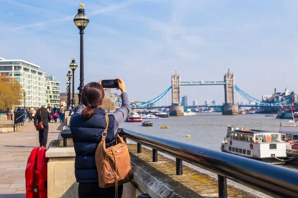 女游客用手机相机在塔桥上拍照. — 图库照片