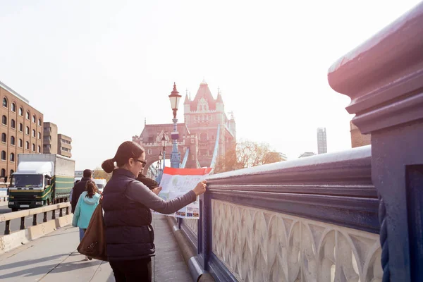 Seyahat kadın Londra Tower Bridge önünde harita bakar, İngiltere. — Stok fotoğraf