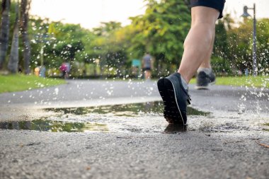 Adam egzersiz su birikintisi ile çalışan ayakkabılarını sıçrayan.