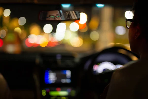Nő vezetés autó bokeh lámpák a forgalmi dugó éjjel. — Stock Fotó