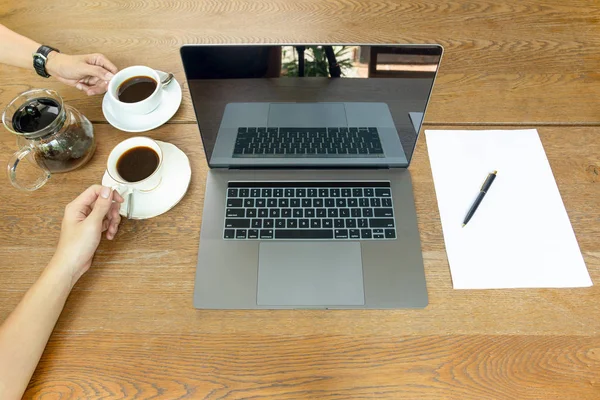 Vista superior de manos de hombre de negocios sosteniendo la taza de café con el ordenador portátil en la mesa . —  Fotos de Stock