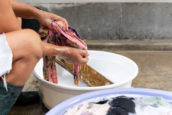 Nő kéz mosás piszkos ruhák nagy tál beton padlón. — Stock Fotó