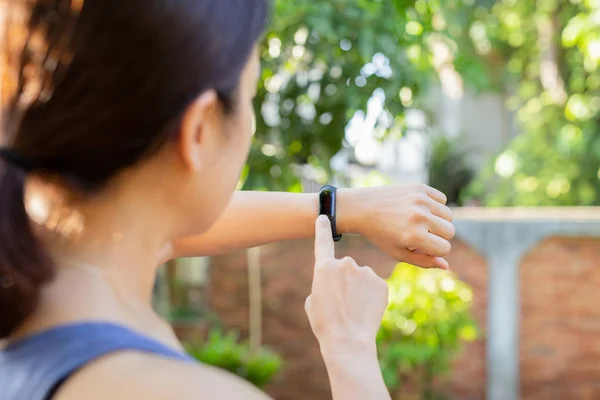 Health care concept woman checking fitness bracelet monitor on smart watch.