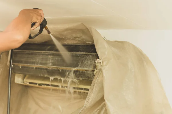 Acondicionador de aire de pared de limpieza de trabajadores con bomba de chorro de agua de alta presión en casa . —  Fotos de Stock