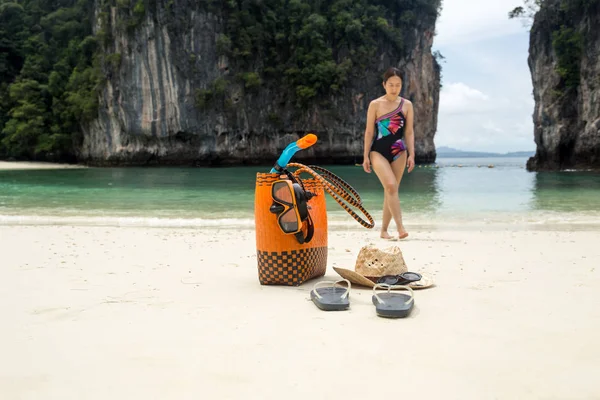 Torba plażowa i akcesoria turystyczne z kobietą w rozmytym tle w letnie wakacje. — Zdjęcie stockowe