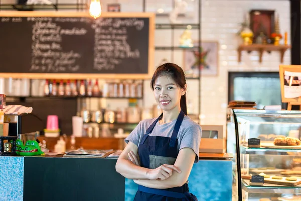 Азиатская бариста, стоящая с улыбкой перед кафе . — стоковое фото