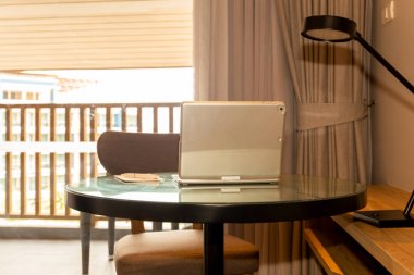 Otel odasında masa üzerinde kalem ve kağıt ile Laptop.