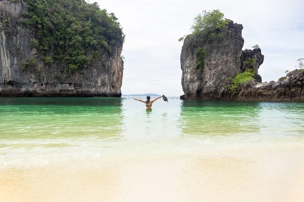 Женщина, стоящая в море и руки вверх держа пляжную шляпу на отдыхе . — стоковое фото